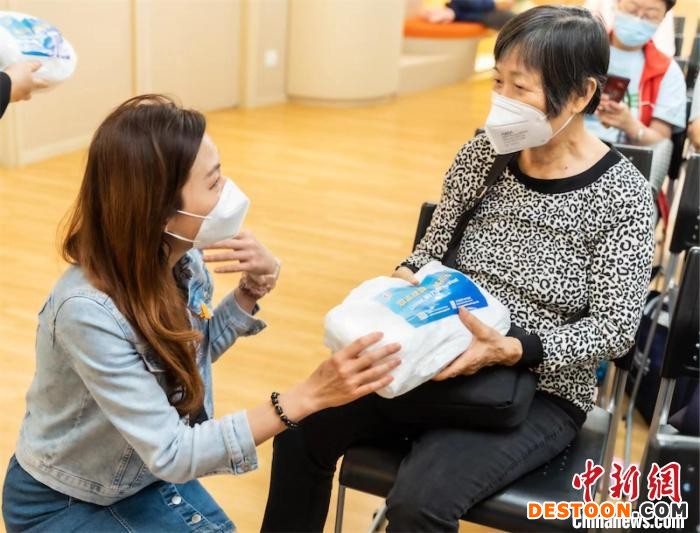 沙田民政事务专员柯家乐(左)向市民派发抗疫物资。 培侨教育机构供图