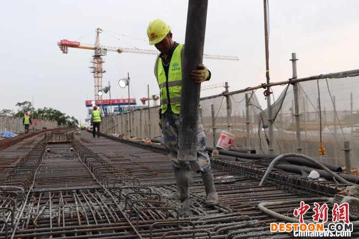 施工人员浇筑混凝土 龚雯 摄
