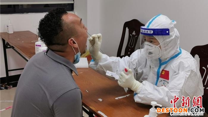 张思邈(右一)为居民进行核酸采样。 白云区政府 供图