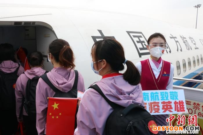 图为中国南方航空广西分公司乘务员在舱门口迎接医疗队员。 刘巍 摄
