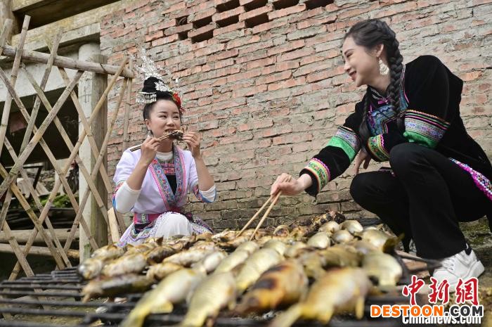 主播在巨洞村“云上谷雨节”活动现场品尝烧鱼。