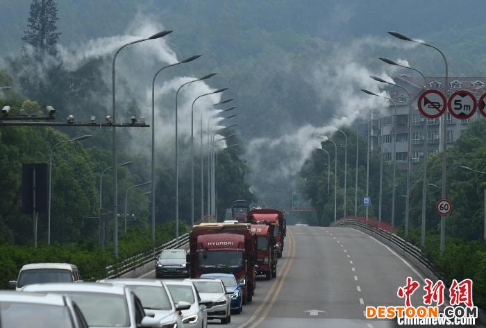 公路两旁的路灯上正喷着水雾。 陈超 摄