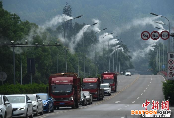 公路两旁的路灯上正喷着水雾。 陈超 摄