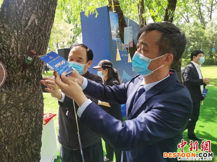与会嘉宾将诗意卡片挂上树枝。 刘鹏 摄