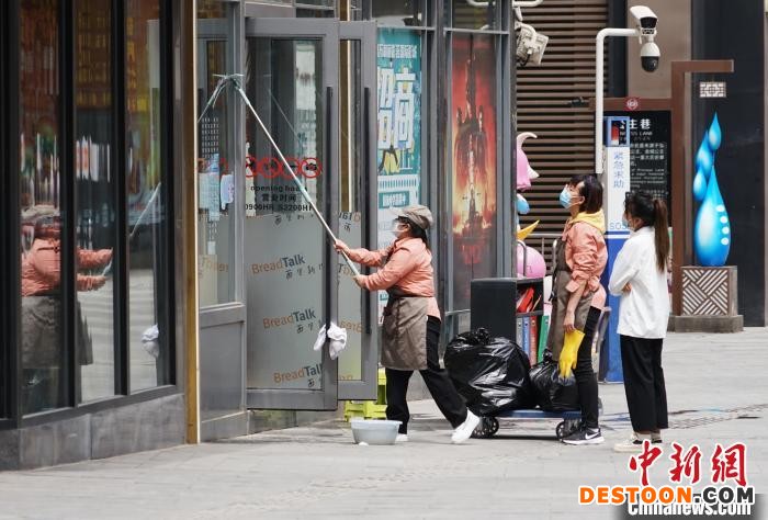 图为商家打扫店面卫生准备营业。 马铭言 摄