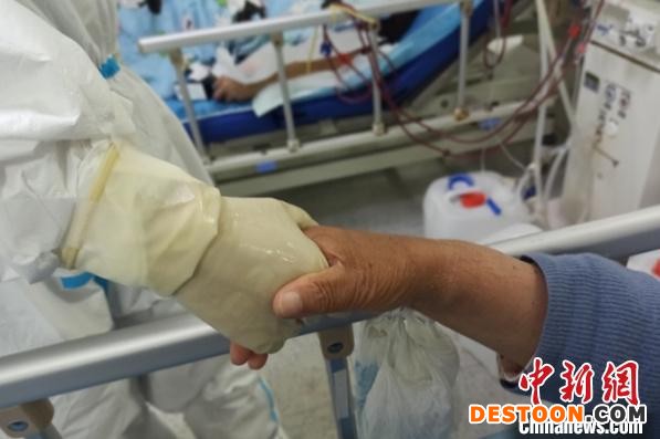 浙江血透医疗队员与患者的手握在一起。 浙江省卫生健康委供图