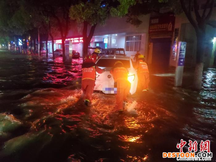 救援人员将私家车移出积水区。 王宇琨 摄