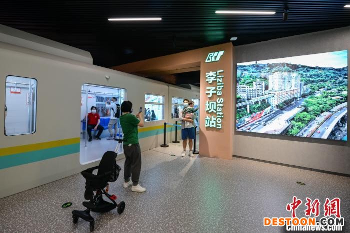 图为观众与重庆规划展览馆新馆的“李子坝轻轨穿楼”景观合影留念。 何蓬磊 摄