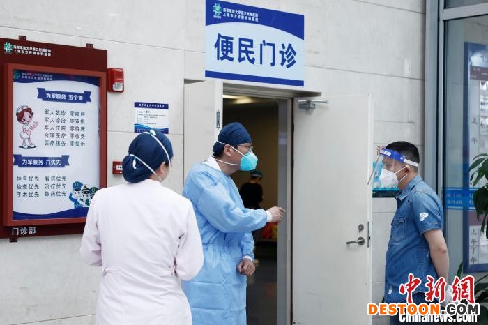 医护人员在便民门诊室外回答市民问题。 殷立勤 摄
