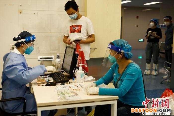 医护人员正在为就医配药市民一一填写病例。 殷立勤 摄