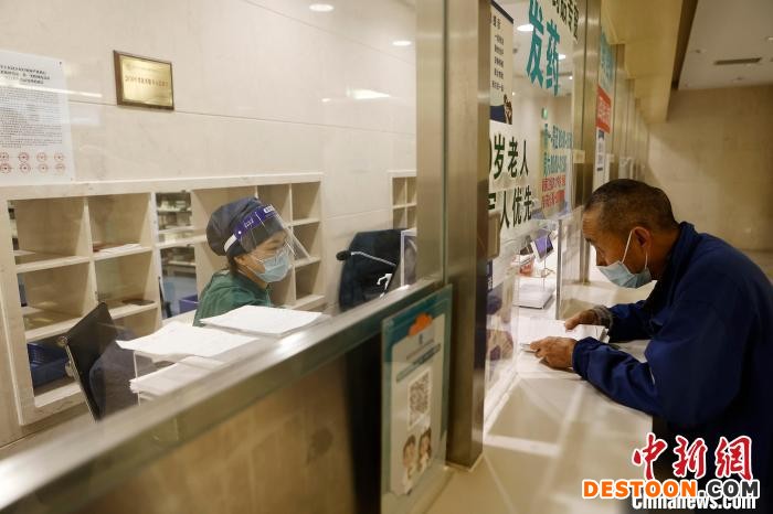 配药市民正在取药窗口拿药。 殷立勤 摄