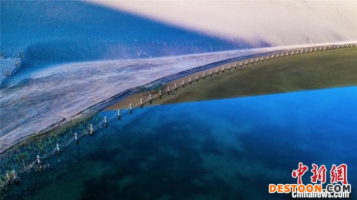 敦煌鸣沙山月牙泉水域面积扩大。图为泉水已逐渐渗出围栏之外。 王斌银 摄