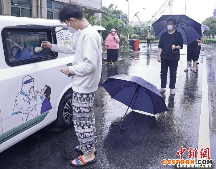 市民正在核酸检测车外进行核酸采样。 殷立勤 摄