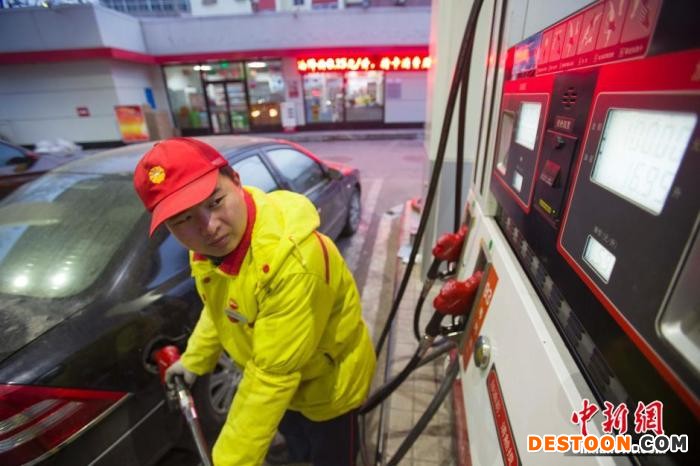 资料图：加油站工作人员为汽车加油。 张云 摄