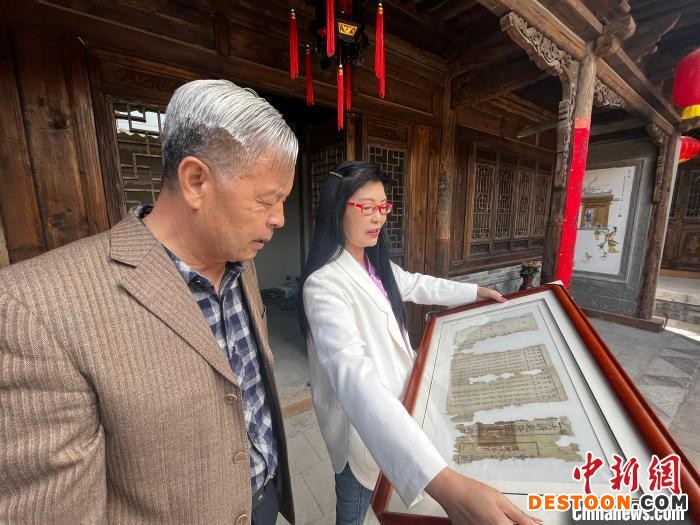 图为专家展示在迁建古民居时发现的可追溯至清代的“房产证”。 王牧雨 摄