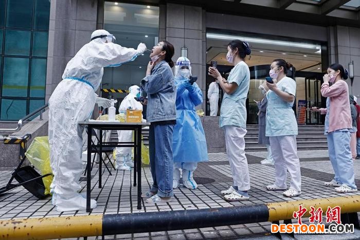 在上海金山路上，民众有序等待进行核酸检测采样。 殷立勤 摄