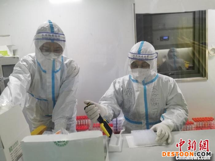 在方舱实验室里工作的抗疫人员。 王佳美 摄