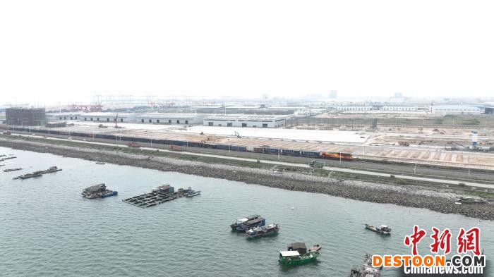 图为列车行驶在海边。 黄堃 摄