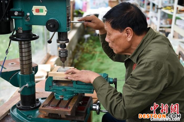 汤家禄正在为石磨打孔。 何蓬磊 摄