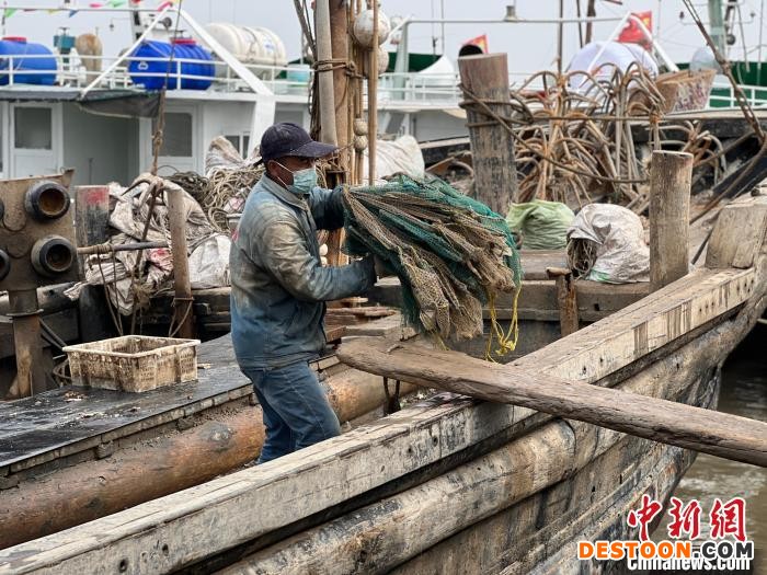 唐山市丰南区黑沿子镇码头渔船返港，渔民收拾网具。