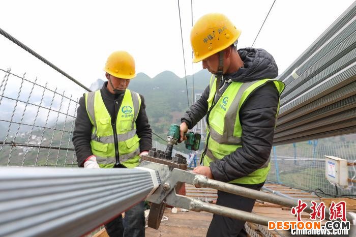 两位工人在大桥猫道上安装握索器。 瞿宏伦 摄