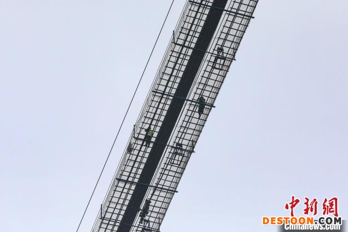 两位工人在大桥猫道上进行索股牵引指挥监控。 瞿宏伦 摄