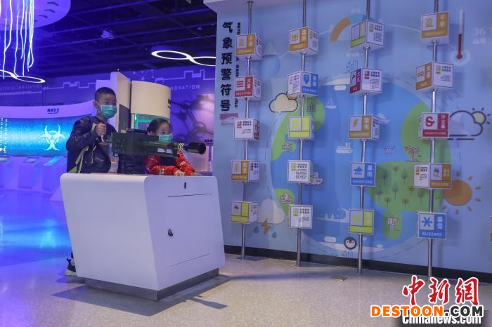 图为两位儿童在体验人工干预天气游戏。 刘力鑫 摄