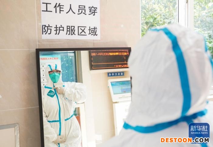 在上海市普陀区利群医院，吴颖在更衣区穿上防护服(4月30日摄)。