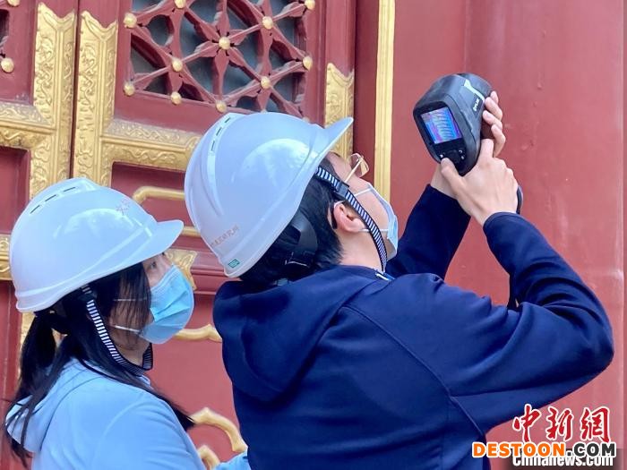 图为张涛和同事用红外热成像仪检测屋面渗漏情况。 徐婧 摄