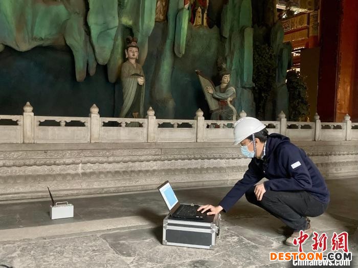 图为张涛用拾振器对极乐世界殿进行结构振动测试。 徐婧 摄