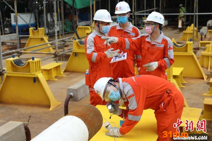 2020年8月27日，青年员工在船体上方检查验收天然气管线，确保管线内部结构完好。 中国海油海南分公司供图