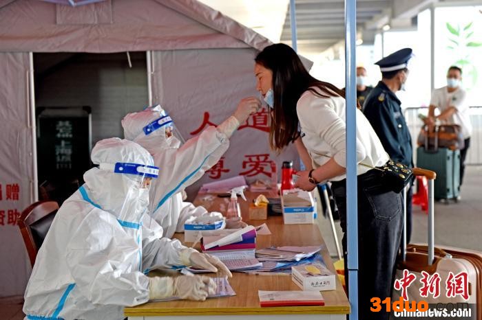 青年志愿者对淮南南站出站旅客进行抗原检测。 陈彬 摄