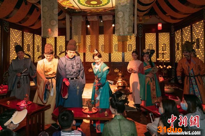 身穿唐朝服饰的演员与游客在酒肆内互动。 西安市曲江新区供图