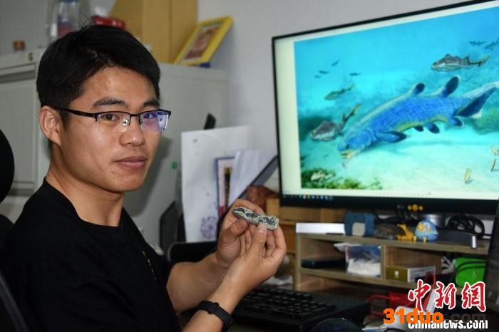 崔心东博士展示介绍杨氏鱼化石标本及研究成果。 中新社记者 孙自法 摄