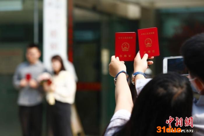 资料图：新人在民政局婚姻登记处外拍照留念。 中新社记者 富田 摄