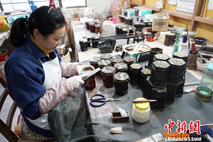 资料图为工人正在为二胡的琴筒部位进行打磨。 孙权 摄