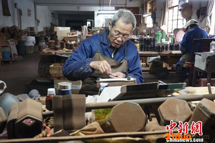 资料图为无锡梅村一家二胡工坊中，老手艺人正在打磨制作二胡的零部件。 孙权 摄