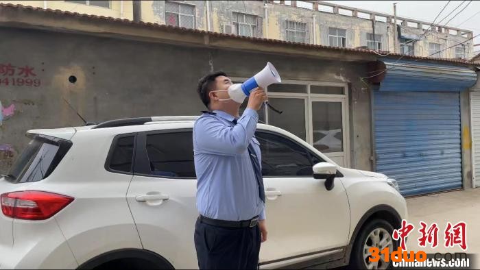 婚礼当天，新郎王凯策在包联小区用喇叭提醒群众下楼做核酸检测。 枣强县公安交警大队 供图