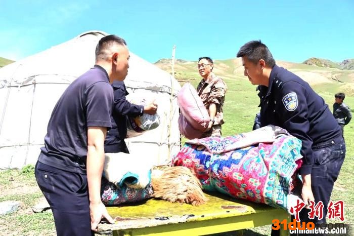 9日上午，蔡森和其他民警帮助转场牧民搭建毡房，搬运东西。 蒋鹏 摄